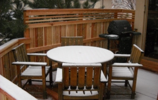 a deck and furniture covered in a light snow