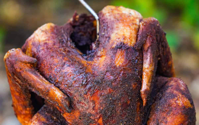 a turkey being lifted from a deep fryer