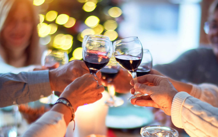 people raising a cheers around the holiday table