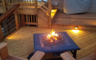 a fire pit burning at dusk on a custom wood deck