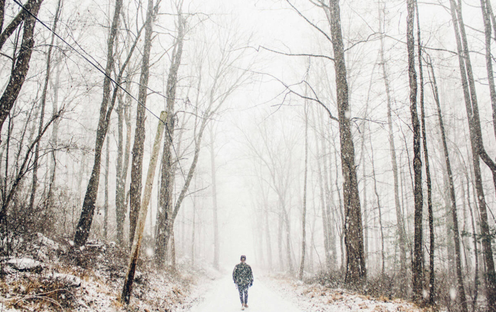 a man walking along a snowy trail