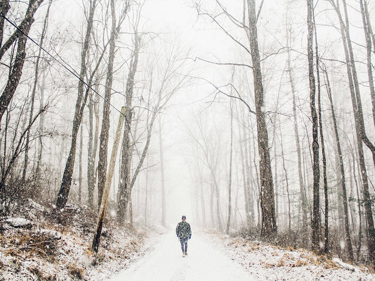 a man walking along a snowy trail