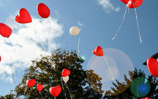 red and white balloons flying into the air