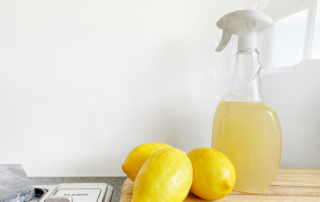 a spray bottle and lemons on the counter