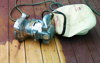 a sander on the board of a partially sanded deck