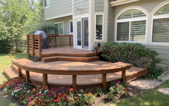 a garden surrounding a custom multi-level wood deck