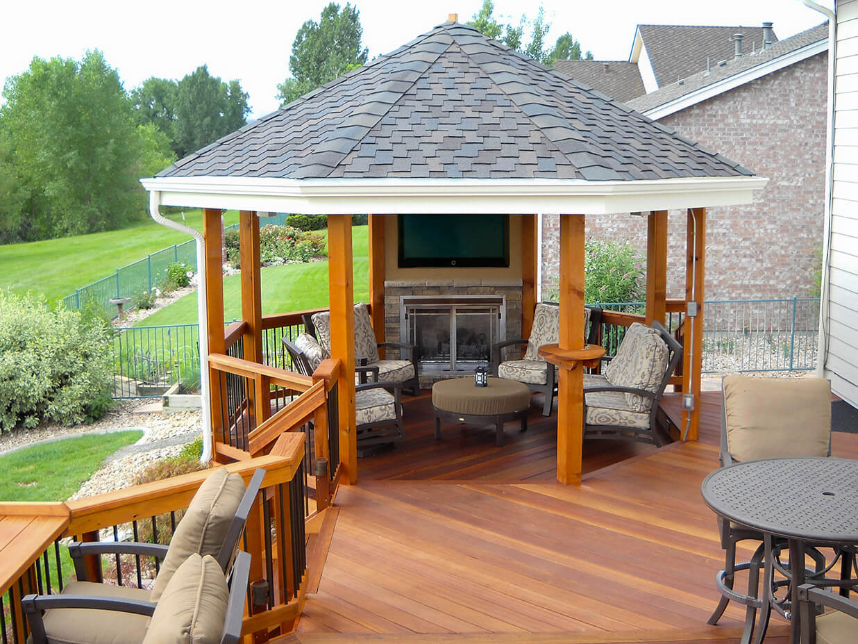 a gazebo with a tv at the end of a custom wood deck