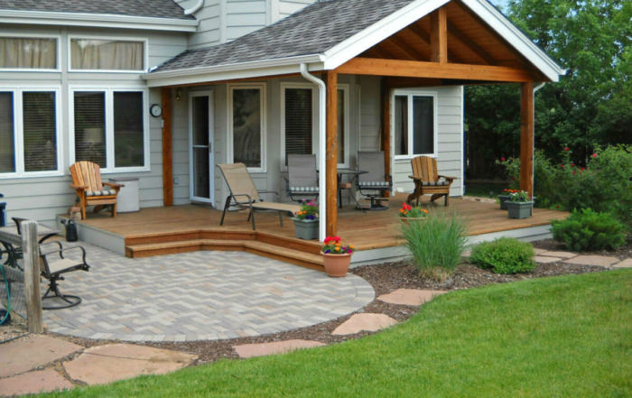 a paver patio connected to a custom roof covered wood deck