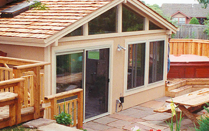 a sunroom connected to decks on either side and a spa