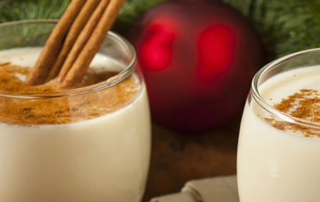 glasses off eggnog with cinnamon sticks