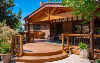 a paver patio leading into a custom wood deck with a roof cover