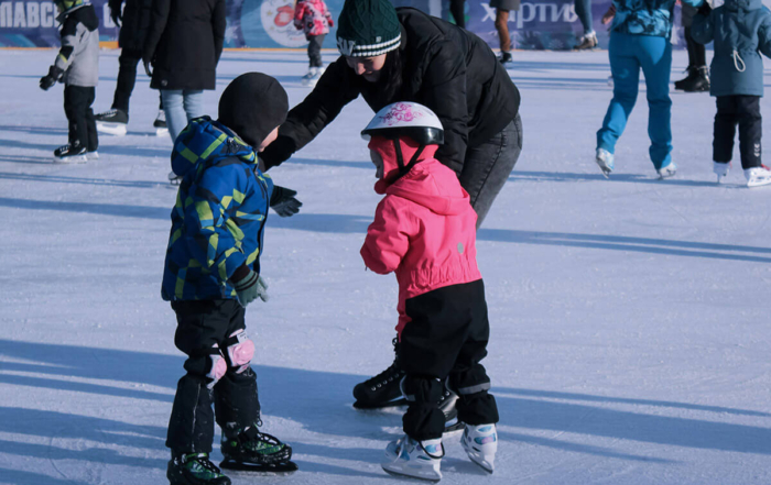 a father teaching his children to ice skate