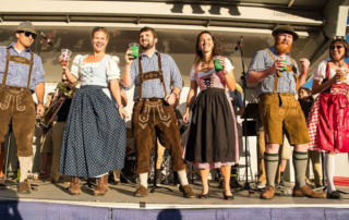 folks dressed for Octoberfest standing on a stage