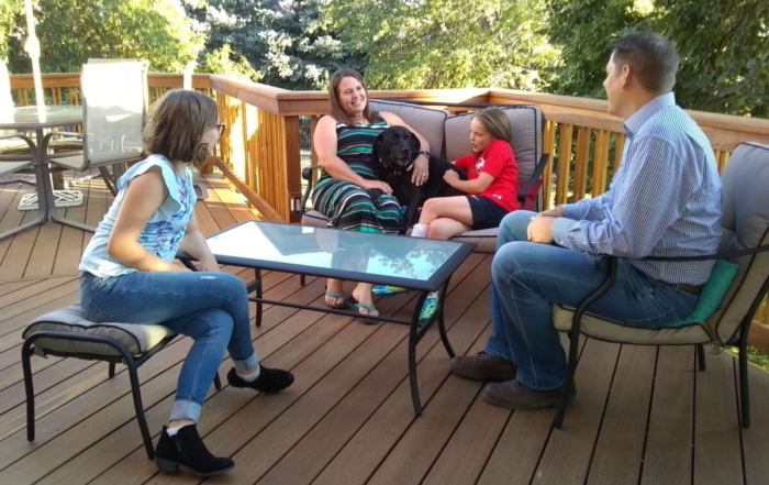 a family sitting on their custom wood deck