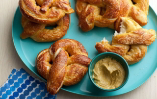 fresh baked pretzels on a plate with mustard