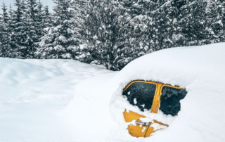 a yellow car buried in snow