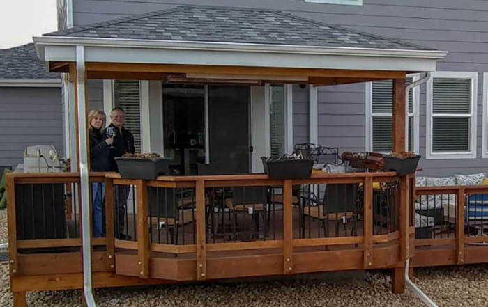 a happy couple standing on their new deck