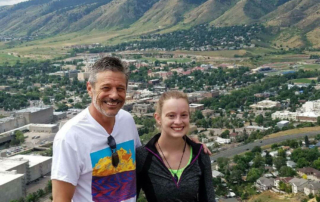 man and his daughter standing above foothills after hike