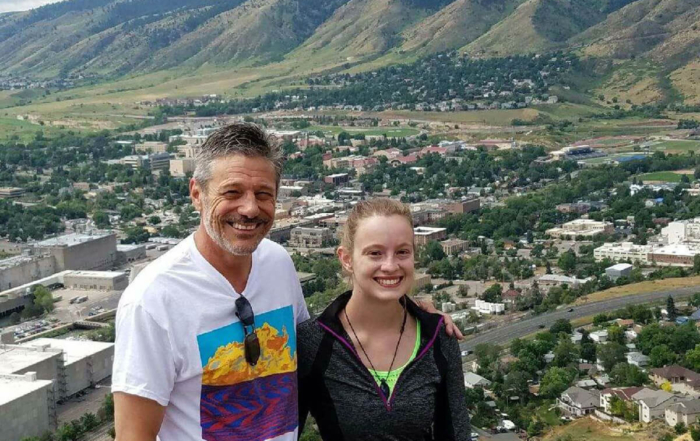 man and his daughter standing above foothills after hike