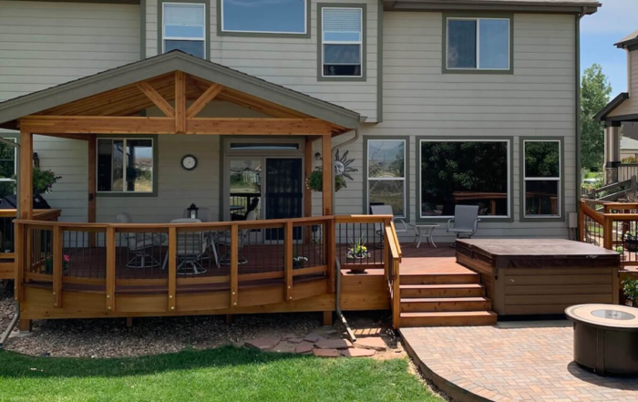 raised wooden deck with a roof cover and hottub