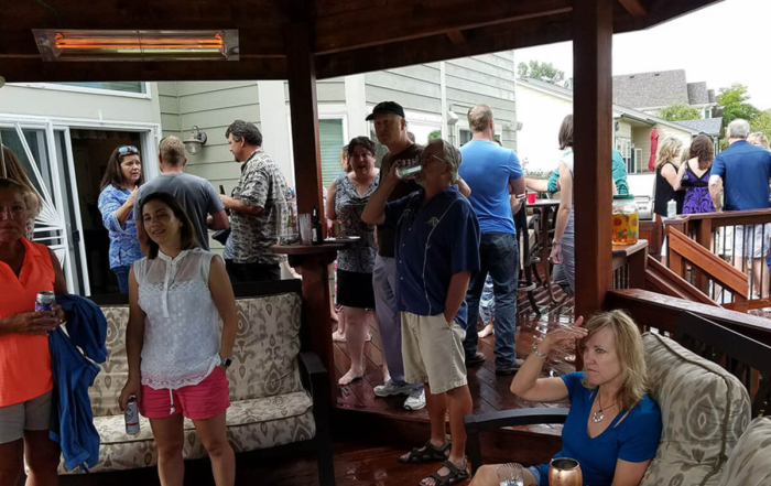 party on deck with people standing under a roof cover