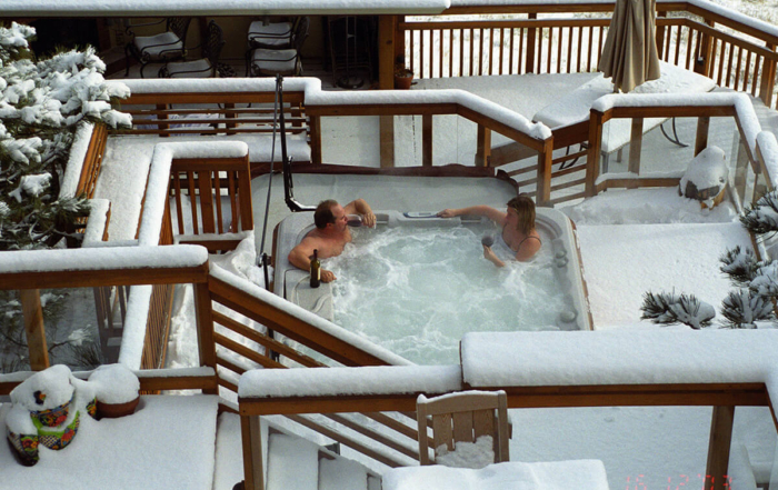 man and woman relaxing in a hottub on their deck