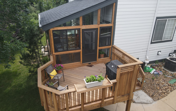 second-level sunroom connected to a raised wood deck and staircase