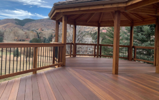 a beautifully stained wood deck with a roof cover