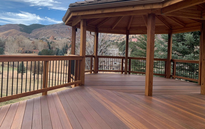 a beautifully stained wood deck with a roof cover