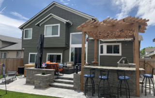 stone patio that leads to a spa and pergola