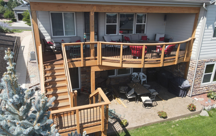 a second-level covered deck with custom rails and staircase