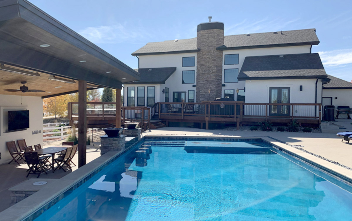 a backyard oasis with pool, covered area, and cuastom deck